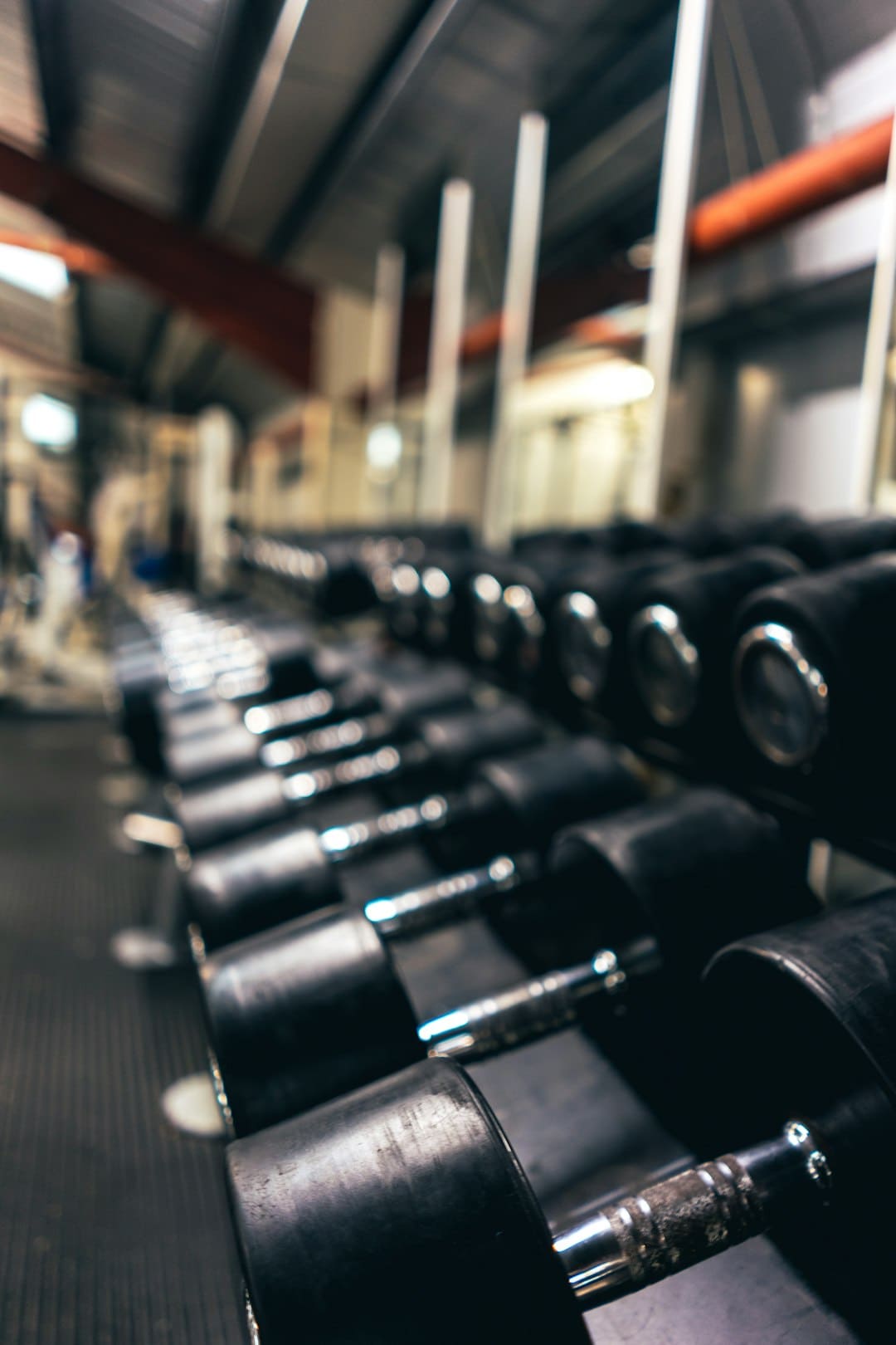 different sizes of gym dumbbells on rack